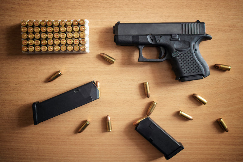 Pistol and bullets on table for pistol shooting drills.